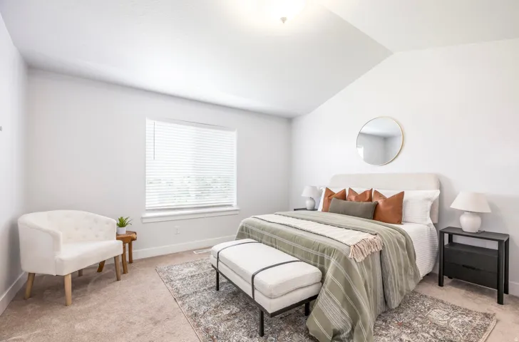 Carpeted room featuring a vaulted ceiling and a rectangular window with blinds