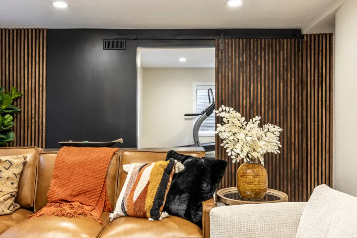 Accent wall featuring vertical wood paneling and a dark painted section