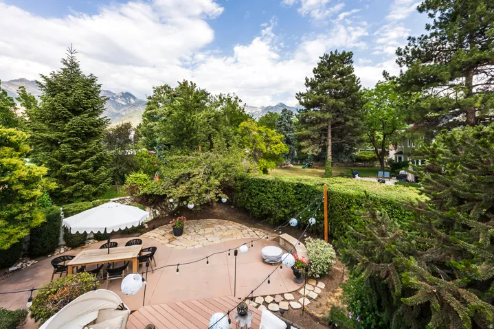 Multi-level outdoor living space featuring a wood-finish deck and concrete patio areas