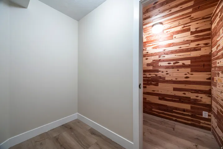 Specialty room featuring wood-panel walls, wood-finish flooring, and overhead lighting