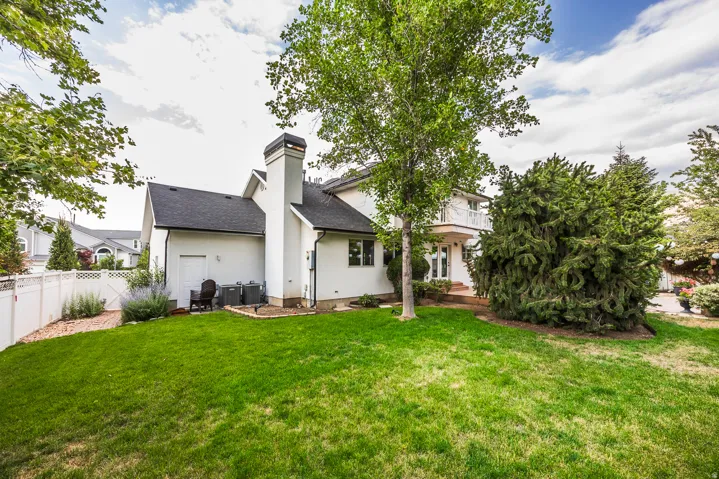Expansive green lawn with mature trees and perimeter landscaping