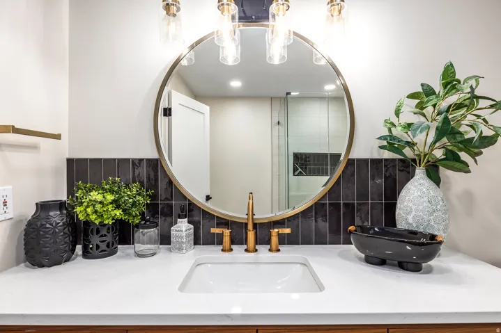 Bathroom vanity featuring a rectangular undermount sink, quartz countertop, and a brass-finish faucet
