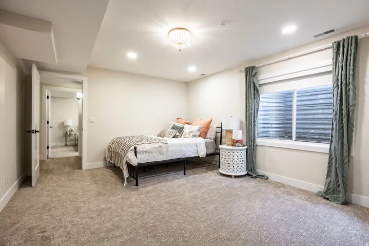 Carpeted room featuring a window with white trim, recessed lighting, and a decorative ceiling light fixture