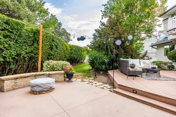Multi-level outdoor space featuring a composite deck with integrated step lighting and a concrete patio