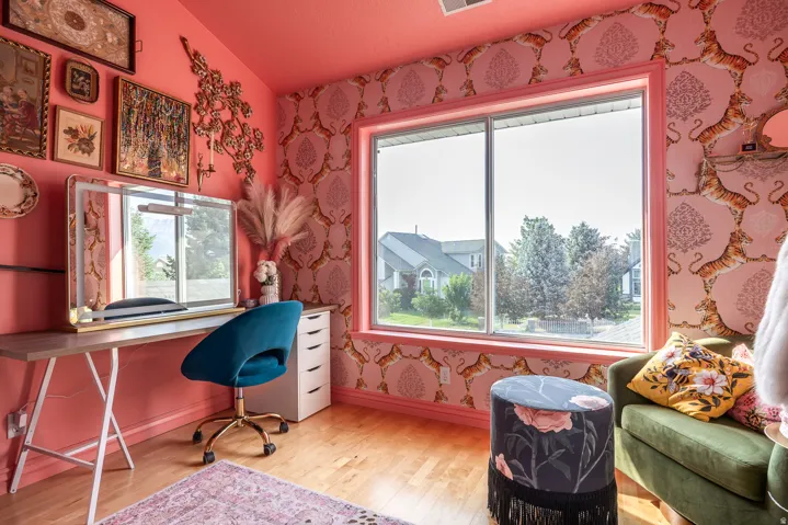 Spacious room featuring a large window, hardwood-finish flooring, and a vibrant color palette