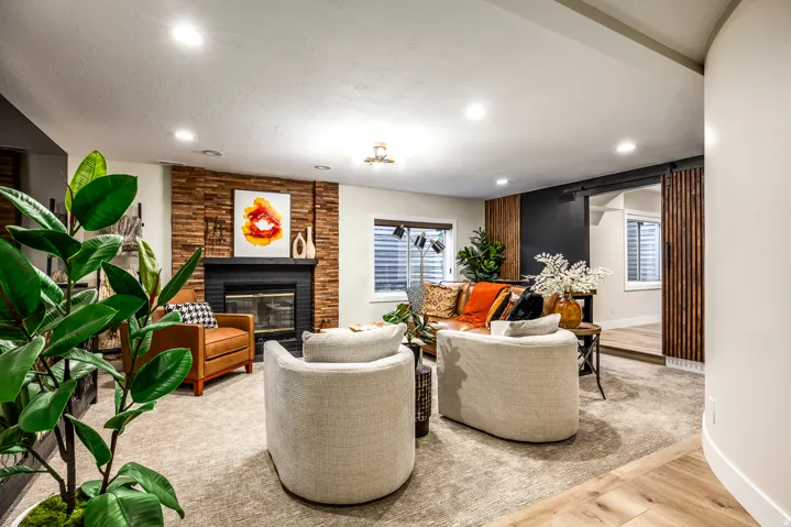 Living area featuring a black fireplace with a stacked wood surround, recessed lighting, and wood-finish flooring