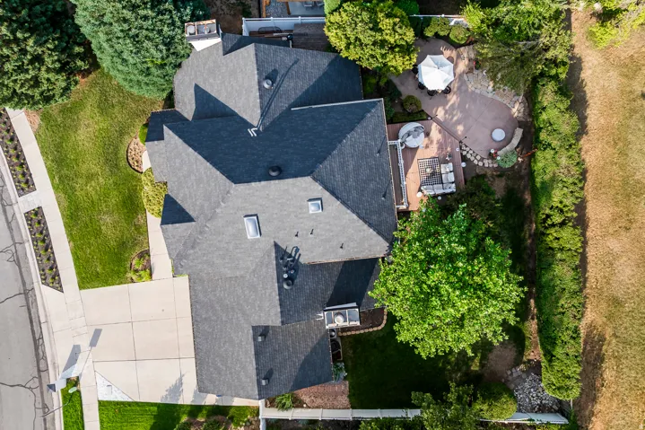 Expansive property featuring a multi-level deck, a stone patio, and mature trees