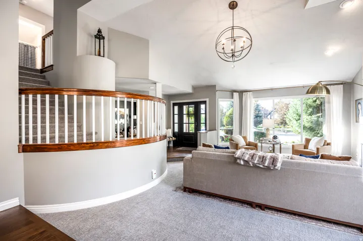 Curved staircase with wood railing and white spindles