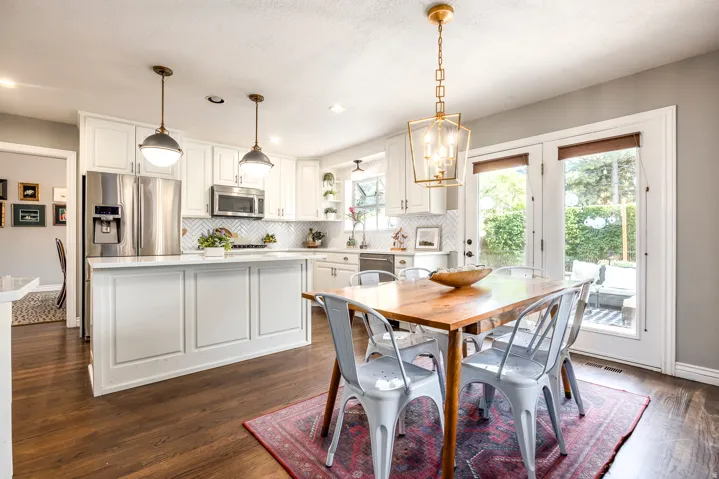 Kitchen featuring white cabinetry, stainless steel appliances, a center island with pendant lighting, and wood-finish flooring