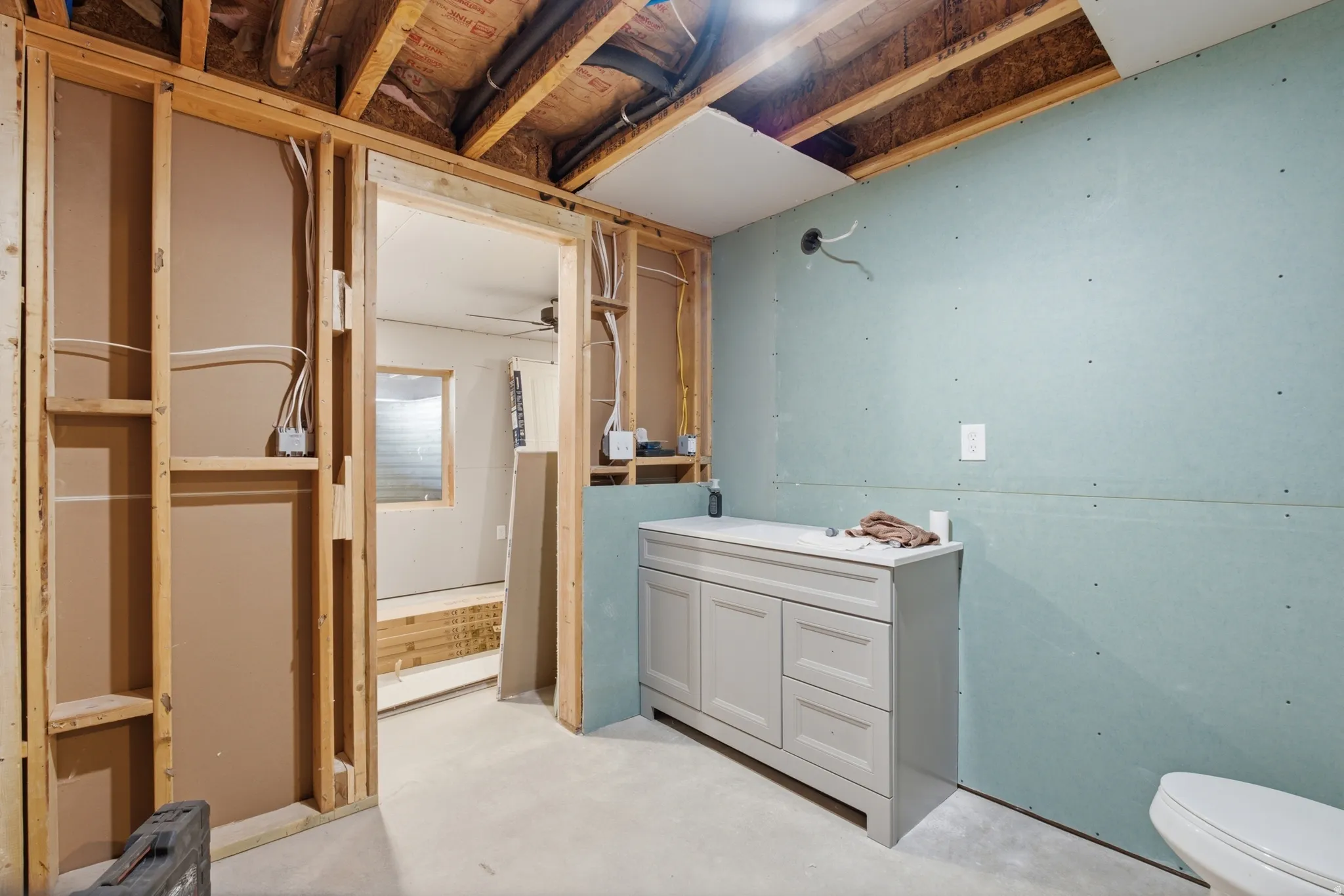 Framed interior space with exposed ceiling joists and partial drywall installation