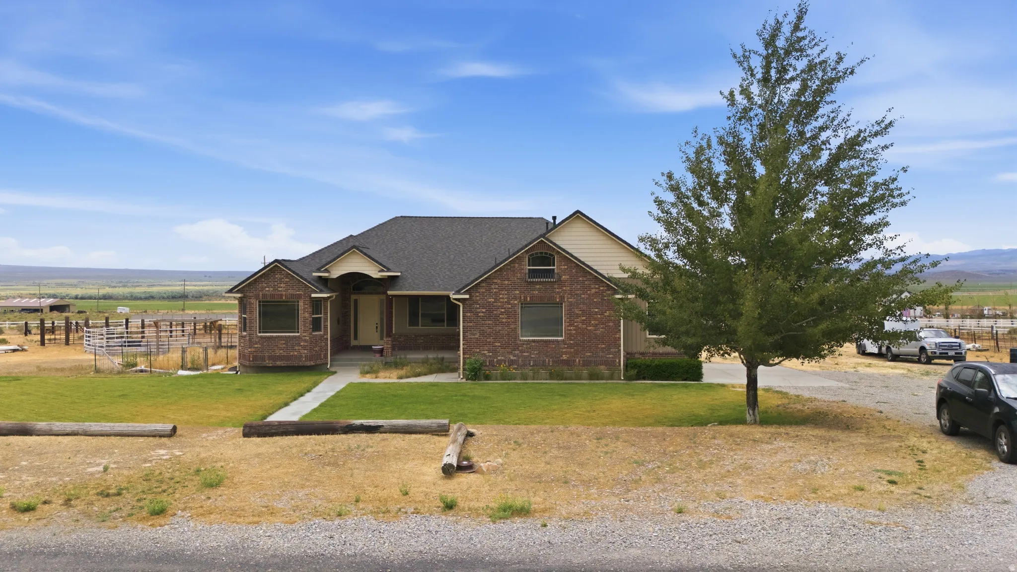 Ranch-style residence featuring a brick facade, dark shingle roof, and a covered front entry