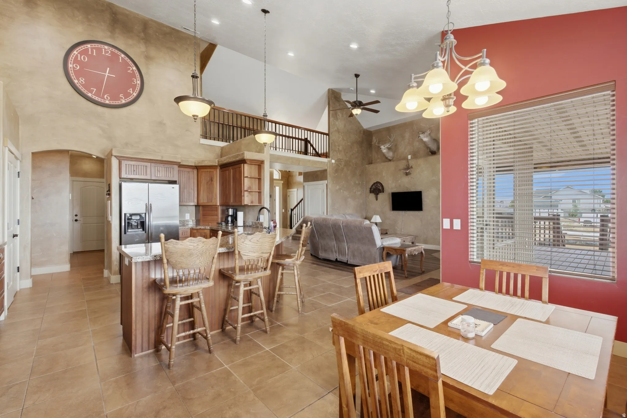 Open-concept living space featuring a kitchen with wood cabinetry and stainless steel appliances