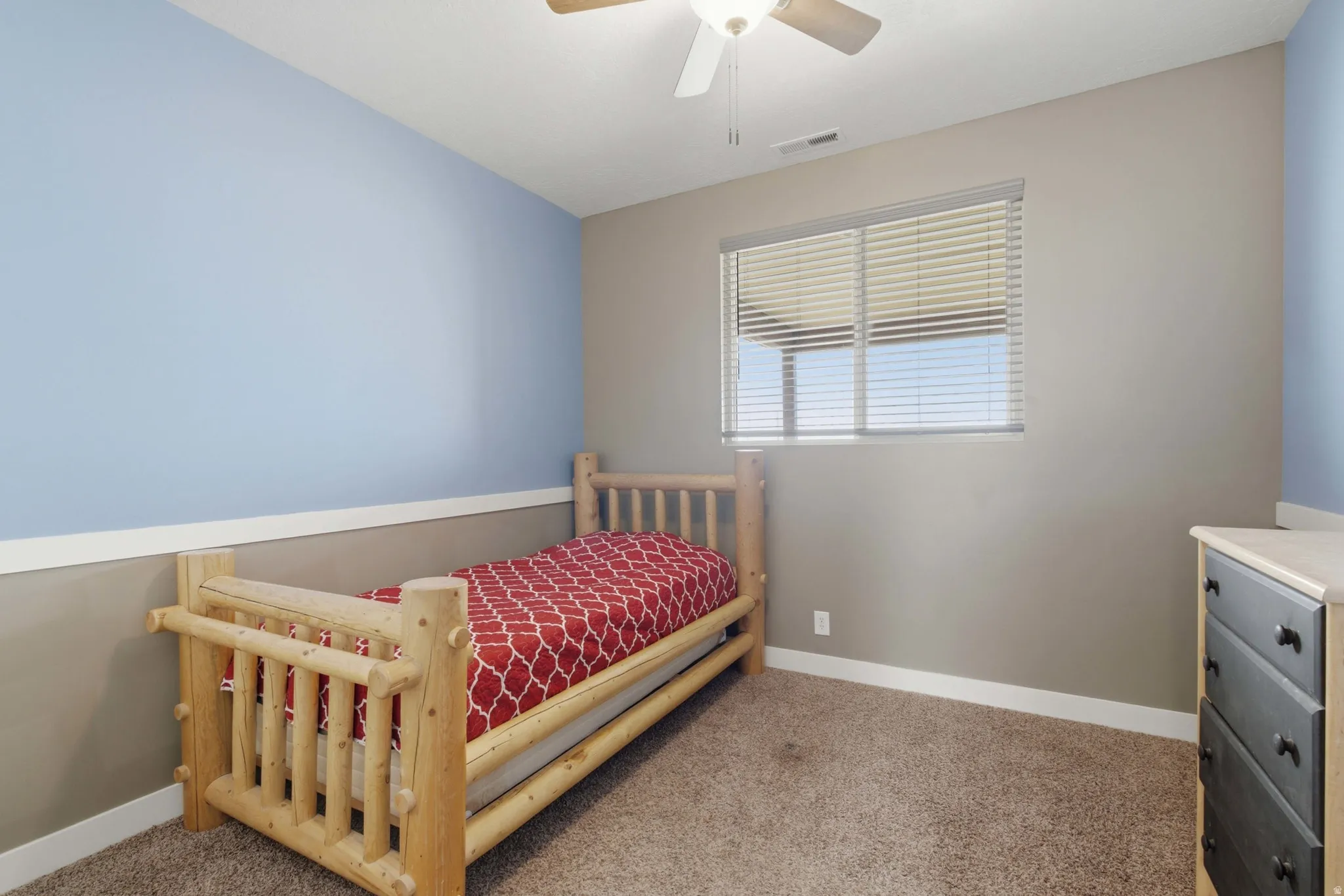Room featuring a neutral wall, light blue accent wall, and a horizontal window with blinds