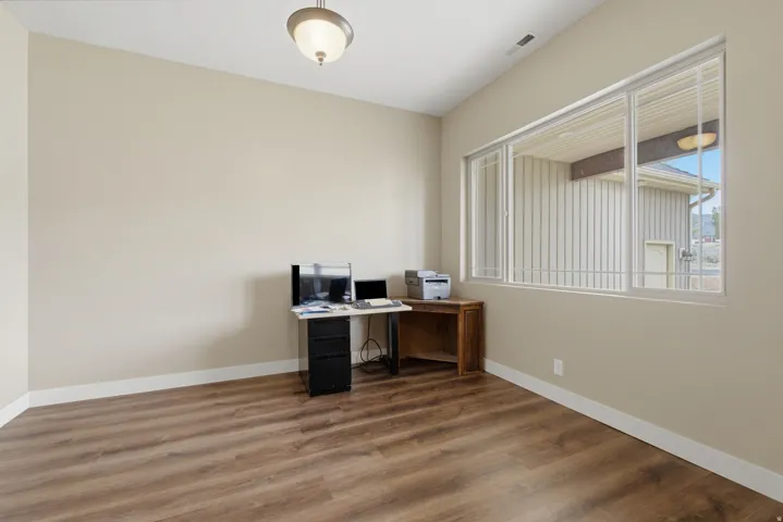 Interior room featuring wood-finish flooring, neutral wall tones, and white baseboards