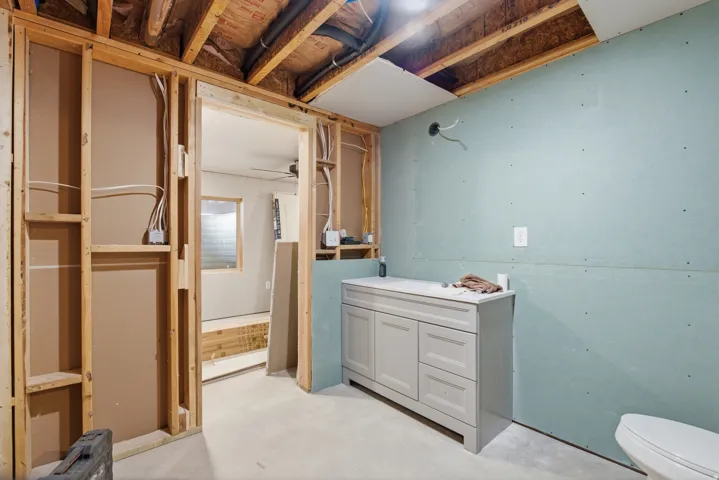 Framed interior space with exposed ceiling joists and partial drywall installation