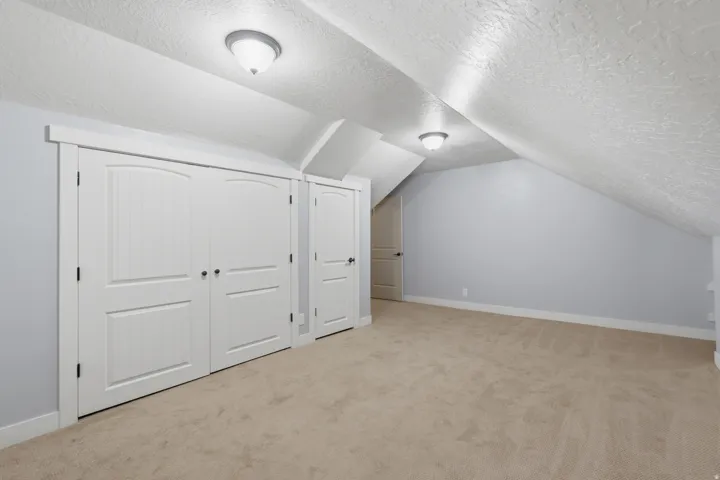 Carpeted room featuring white trim and baseboards, light blue walls, and multiple white panel doors