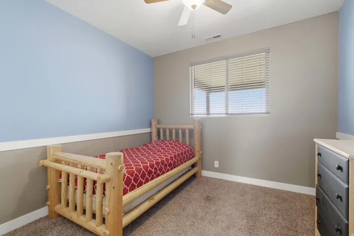 Room featuring a neutral wall, light blue accent wall, and a horizontal window with blinds