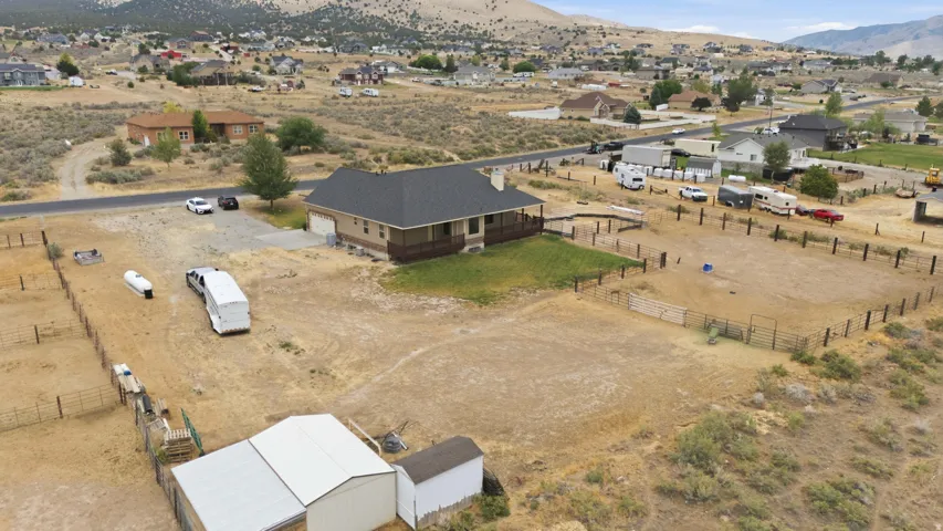 Ranch-style residence featuring a covered front porch, an attached garage, and a fenced perimeter