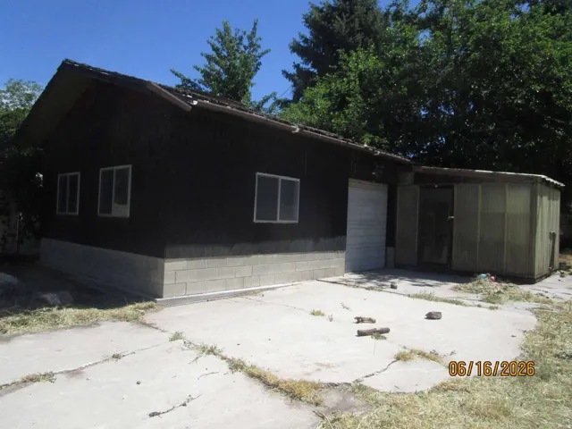 Single-story structure featuring dark siding and a concrete block foundation