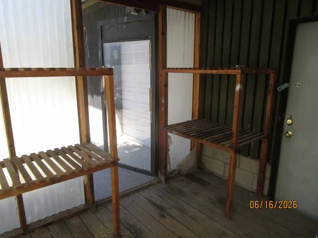 Enclosed porch with translucent paneling, wood-finish flooring, and a glass-paneled entry door