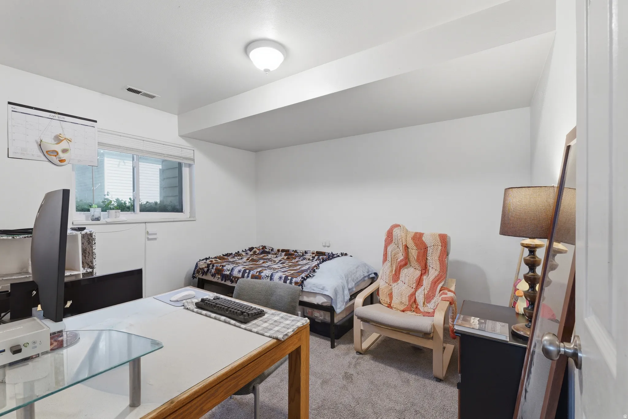 Carpeted room with a recessed window, white walls, and a ceiling-mounted light fixture