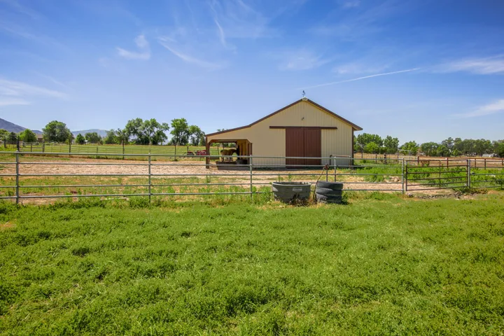 Cream-colored barn featuring a brown roof and sliding doors