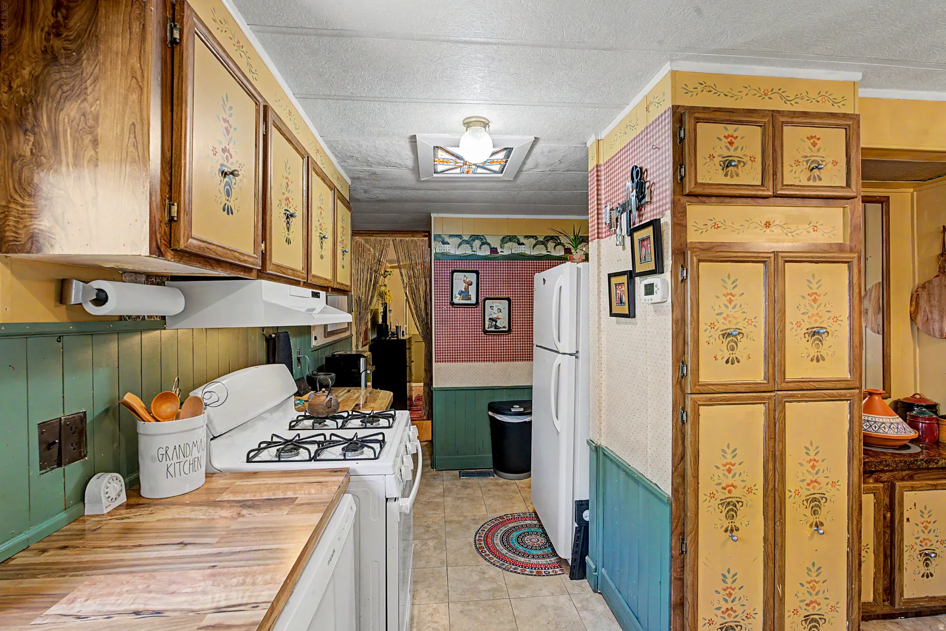 Kitchen featuring wood-finish countertops, a white gas range, and a white refrigerator