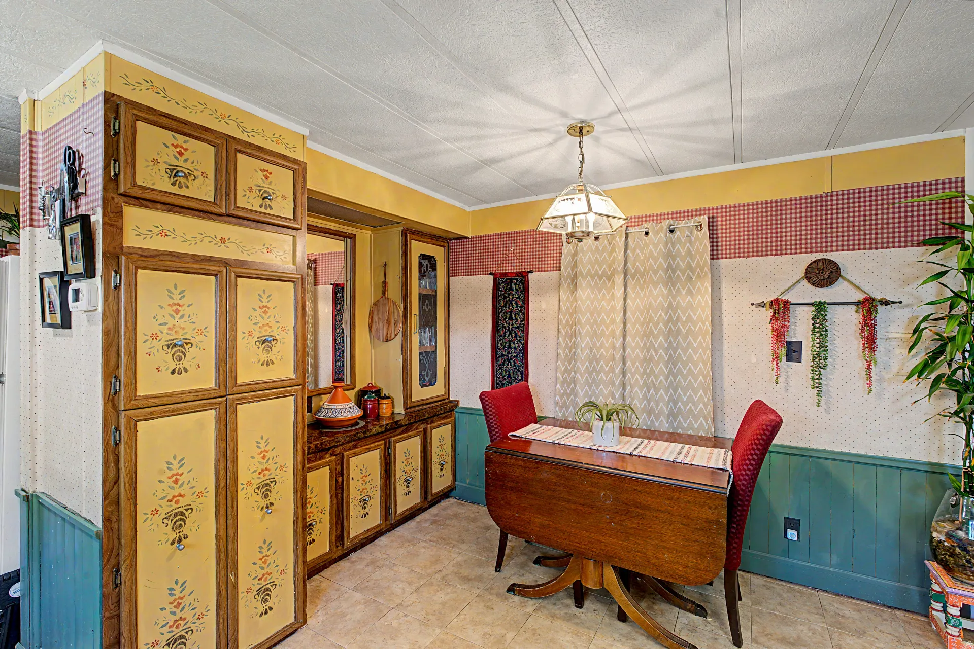 Dining area featuring a drop-leaf table with two chairs, illuminated by a decorative pendant light