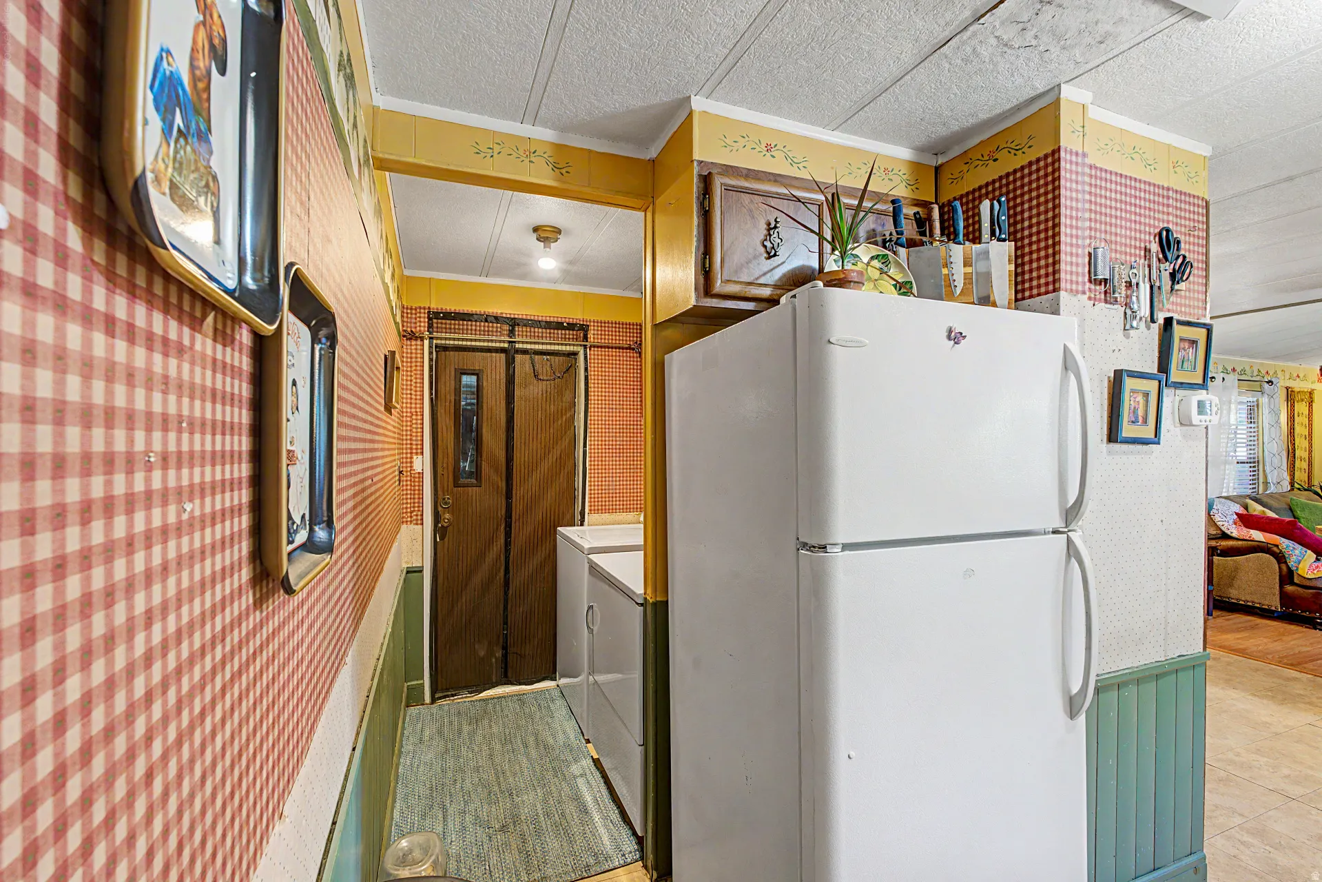 Kitchen area featuring a two-door refrigerator, built-in cabinetry, and a patterned wallpaper design