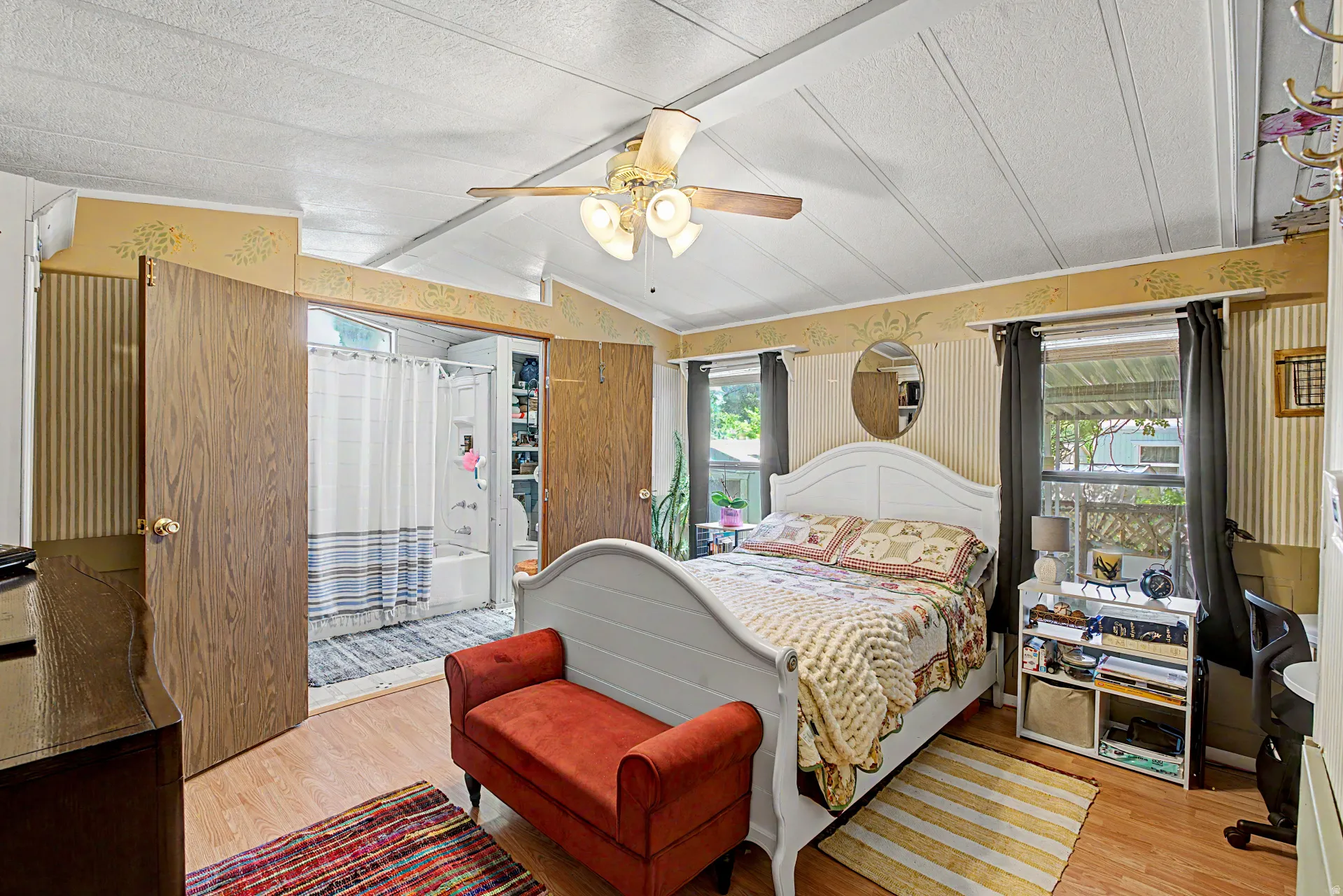 Bedroom featuring wood-finish flooring and a vaulted ceiling with exposed beams
