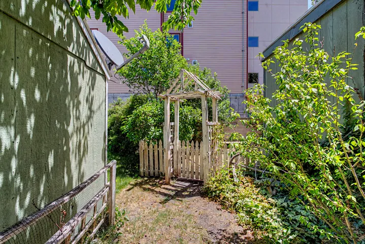 Gated garden entry with picket fence and mature foliage
