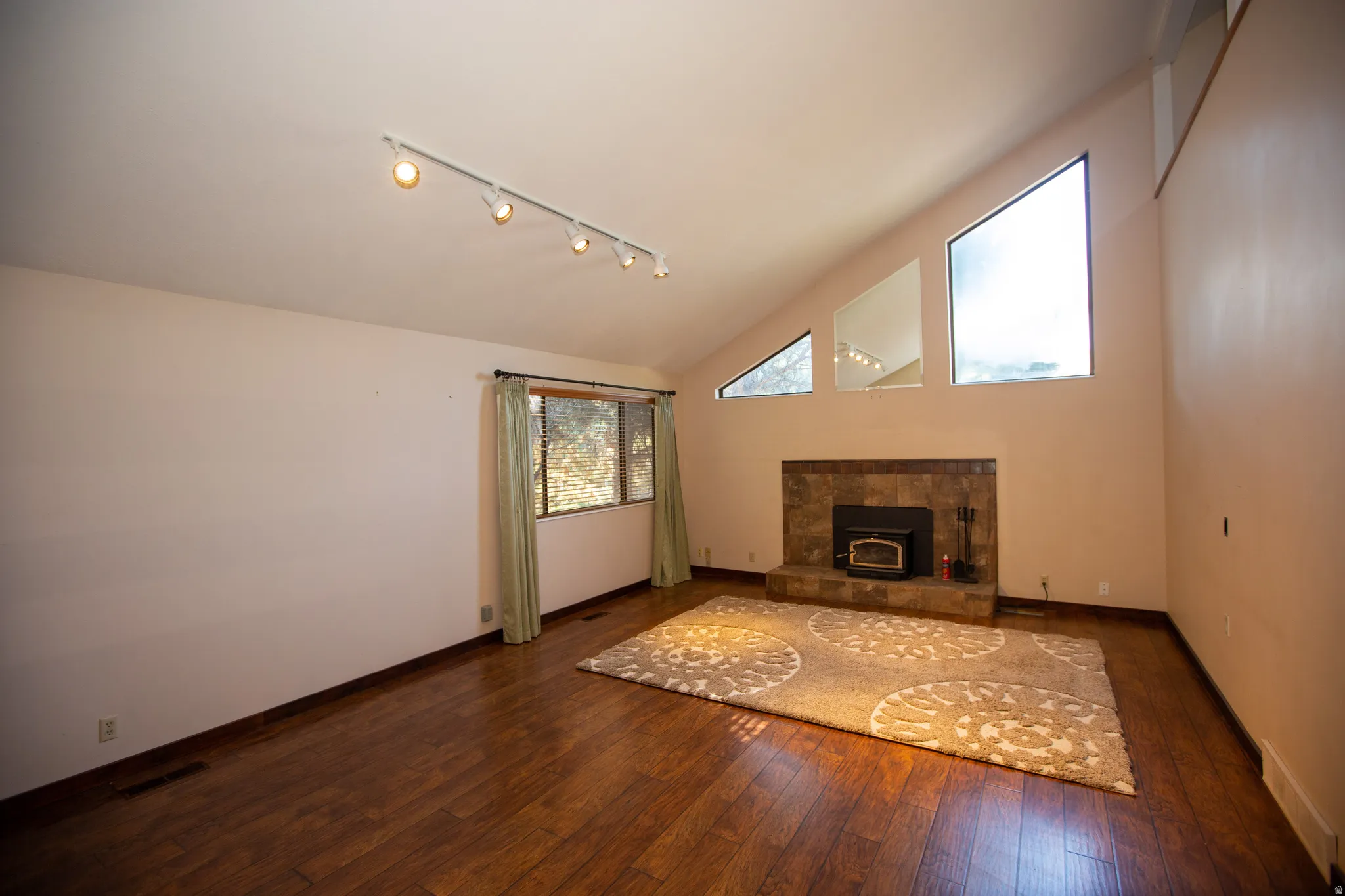 Great room featuring a vaulted ceiling and wood-finish flooring