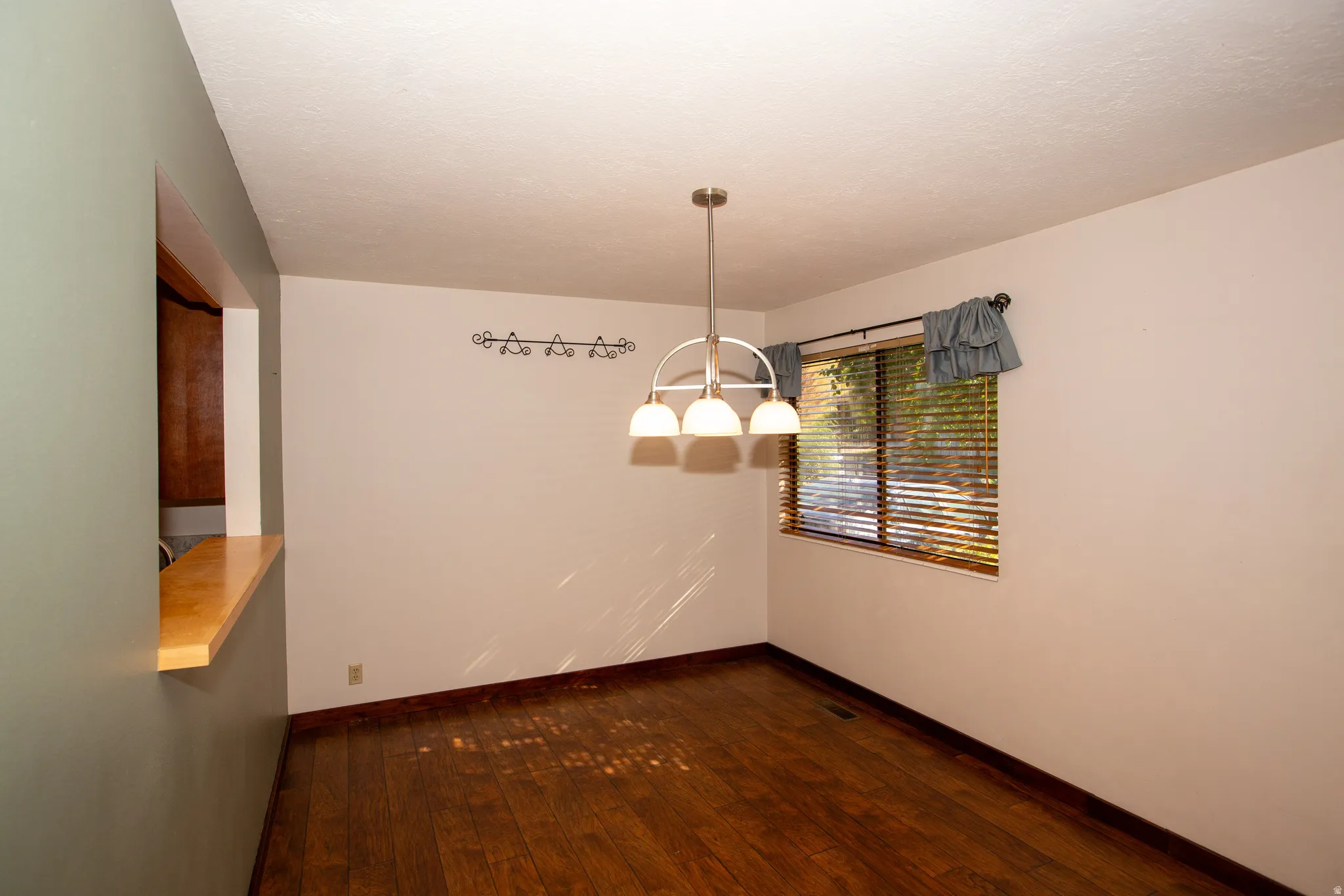 Wood-finish flooring throughout, featuring a pass-through window with a wood-finish countertop