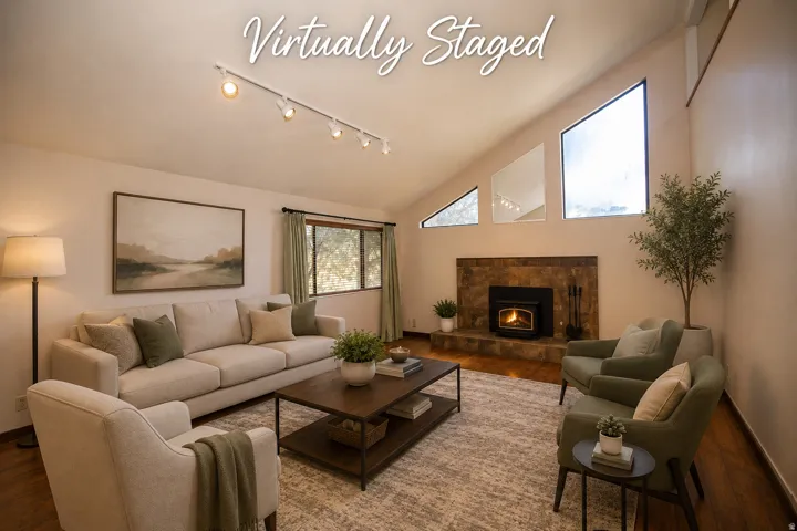 Vaulted ceiling with track lighting, stone-clad fireplace with hearth, and angular window array