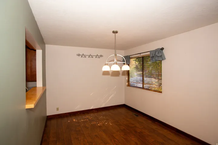 Wood-finish flooring throughout, featuring a pass-through window with a wood-finish countertop
