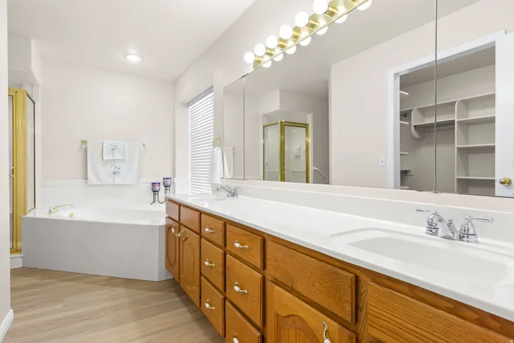 PRIMARY - Bathroom featuring a double vanity with wood cabinetry, integrated sinks, and chrome fixtures