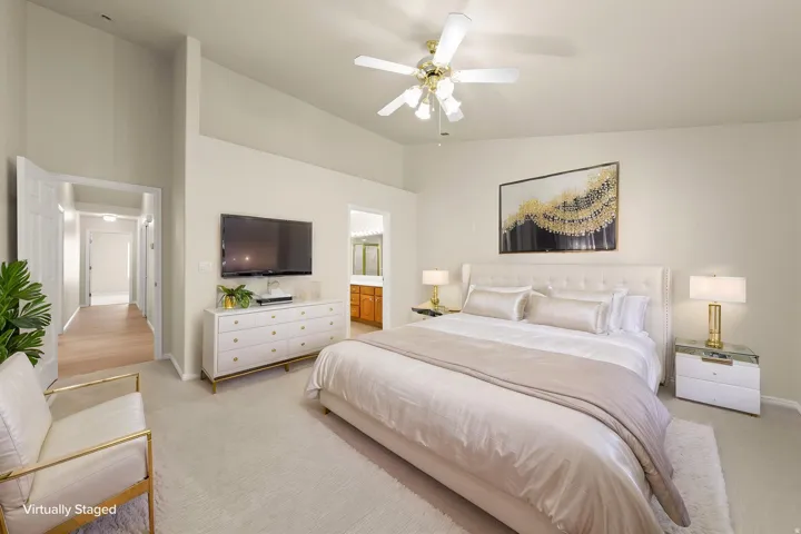 PRIMARY SUITE - Spacious room featuring vaulted ceilings, a ceiling fan with integrated lighting, and neutral-toned wall paint