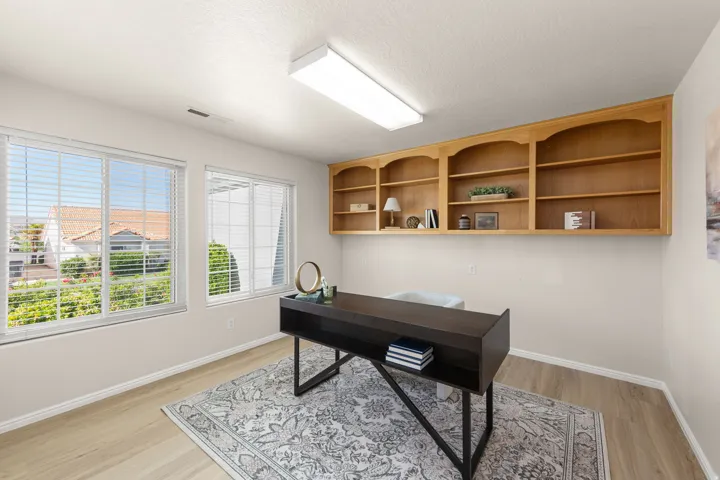 Office, den, flex space featuring built-in wooden shelving, light wood-finish flooring, and multiple windows