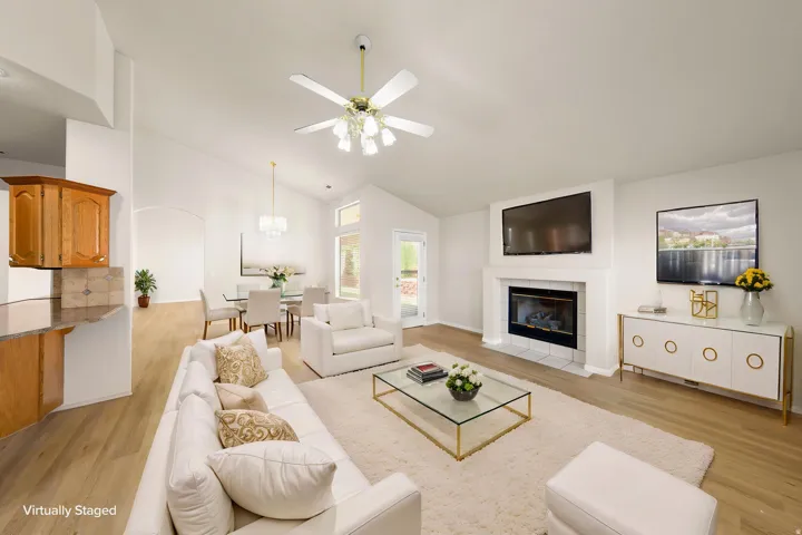 VIRTUALLY STAGED -  Interior with vaulted ceilings, wood-finish flooring, and a central fireplace with a white mantel