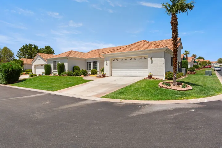 Single-story residence featuring a tile roof, light-colored stucco exterior, and an attached two-car garage