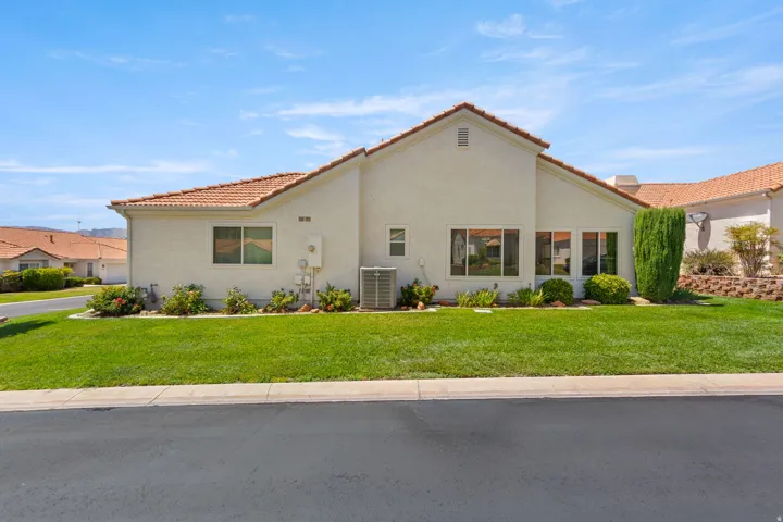 Stucco exterior residence featuring a tile roof and multiple windows