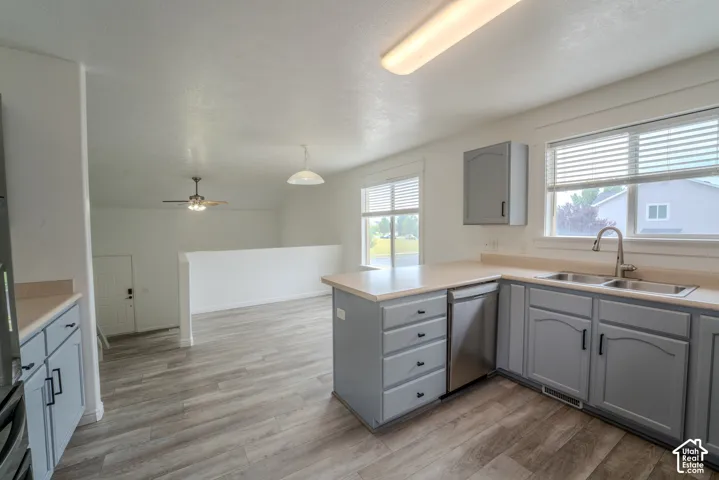 Kitchen featuring gray cabinetry, a stainless steel double basin sink, and a built-in dishwasher