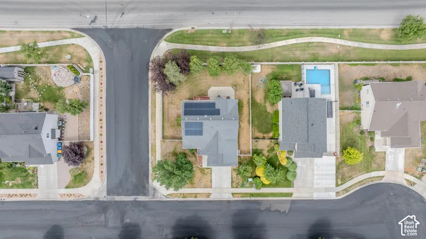 Aerial perspective showcasing a residential property with a private swimming pool, concrete patio, and mature landscaping