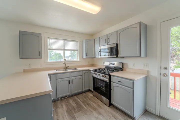 Kitchen featuring wood-finish flooring and grey cabinetry