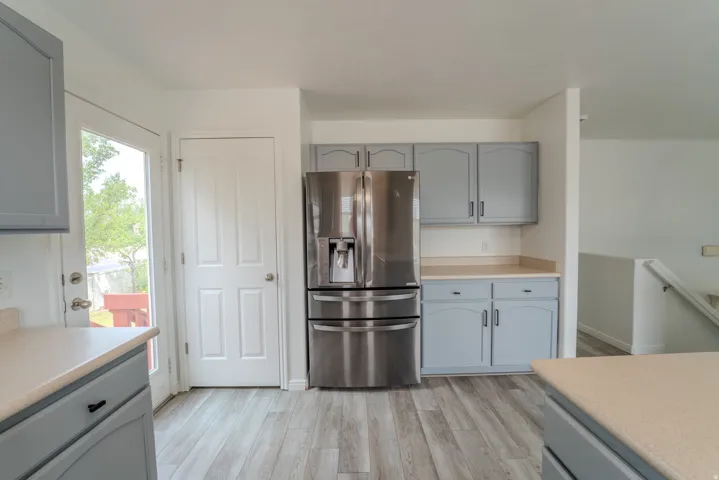 Kitchen featuring light gray cabinetry, light-toned countertops, and wood-finish flooring