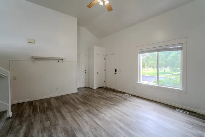 Spacious living area featuring wood-finish flooring and a vaulted ceiling