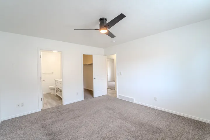 Spacious room featuring neutral carpeting and white walls