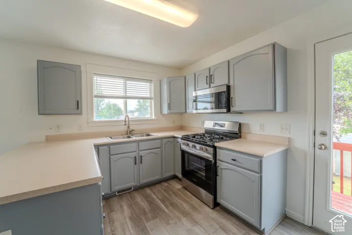 Kitchen featuring wood-finish flooring and grey cabinetry