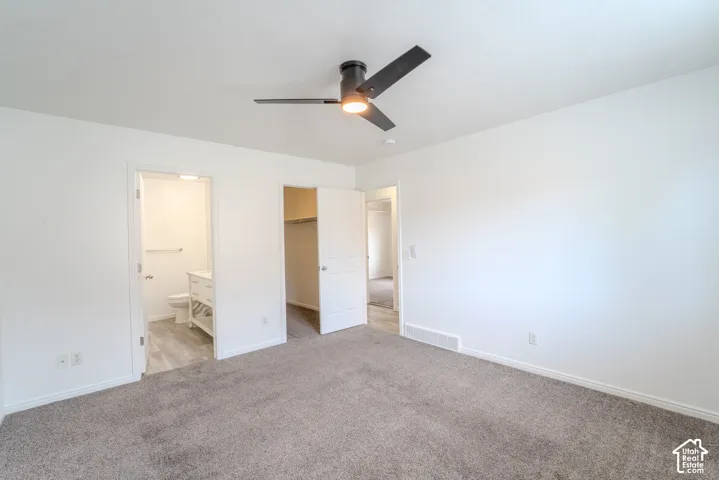 Spacious room featuring neutral carpeting and white walls