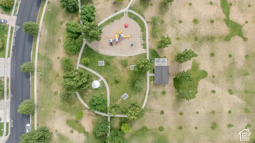 Neighborhood park featuring a playground area with soft ground cover, paved walking paths, a gazebo, and a shaded structure